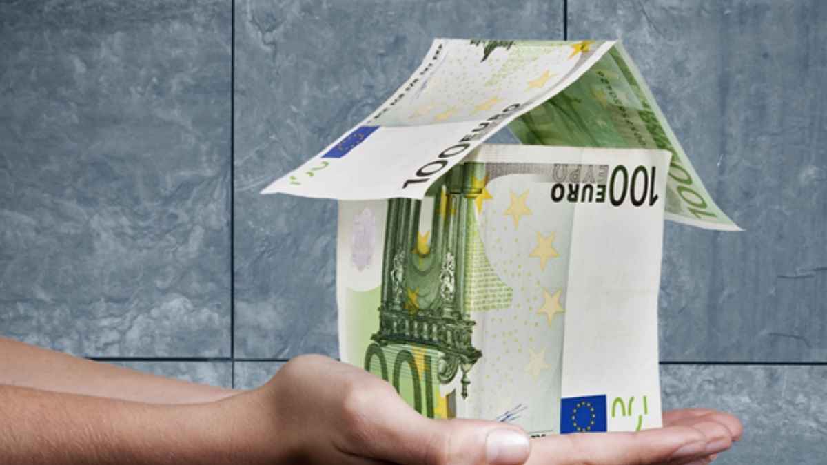 Casa hecha con billetes de euro sobre una mano, imagen sobre la fianza del alquiler y las multas por no depositarla