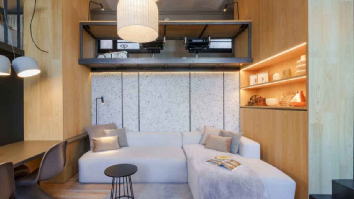 Interior de un minipiso moderno con altillo, sofá y muebles compactos diseñado para alquiler