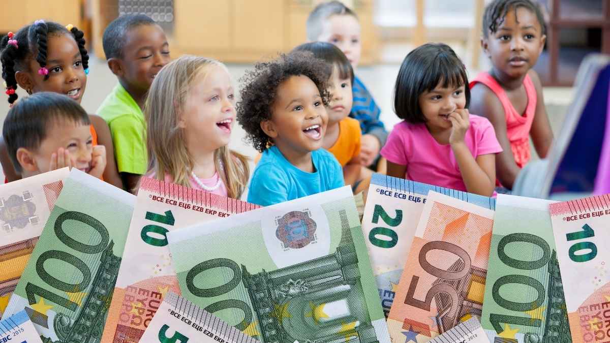 Niños en un aula junto a billetes en una imagen sobre las ayudas escolares de Valencia