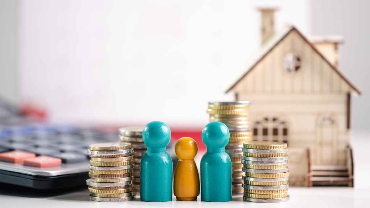 Monedas apiladas junto a una maqueta de casa y varias figuras, imagen sobre las ayudas al alquiler en 2026
