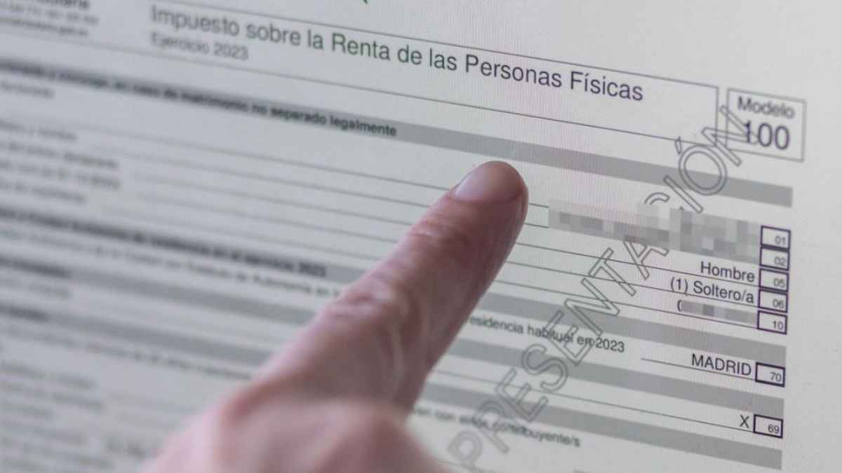 Persona señalando el borrador de la declaración de la renta en el modelo 100 del IRPF