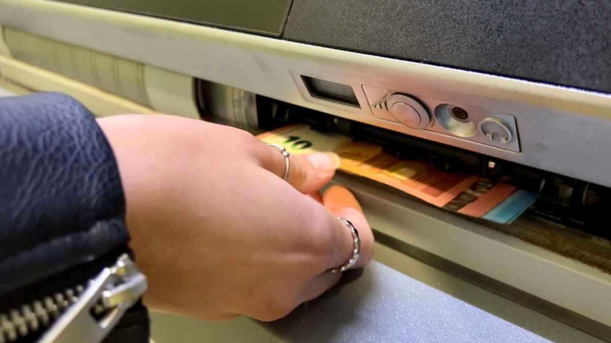 Una persona retira dinero en efectivo de un cajero automático en una imagen sobre los nuevos métodos para sacar efectivo en Europa