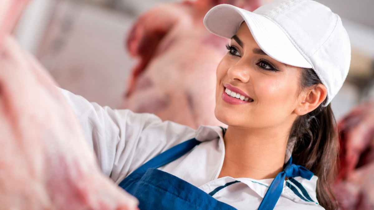 Carnicera en un matadero de Finlandia revisando una pieza de carne durante su jornada de trabajo