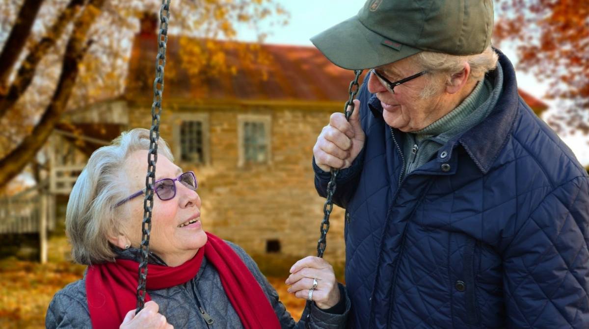 Personas mayores jubiladas conversando en parque representando el sistema de pensiones en Suiza y España