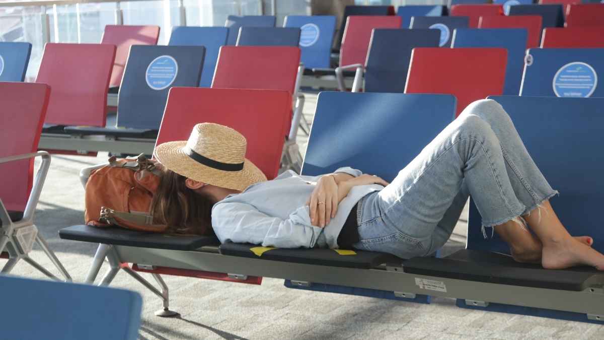 Pasajera tumbada en los asientos de un aeropuerto por el retraso de su vuelo