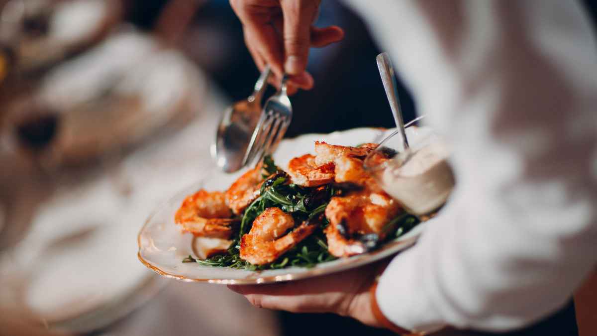 Plato de mariscos con camarones sobre una cama de espinacas servido en un restaurante