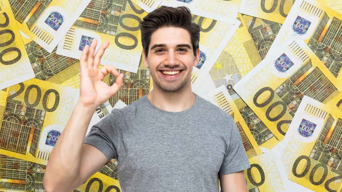 Trabajador sonriente delante de billetes de euro tras cobrar una indemnización millonaria por vacaciones acumuladas