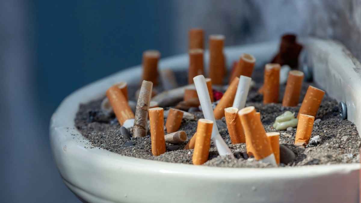 Cenicero lleno de colillas de tabaco en una pausa para fumar fuera del trabajo