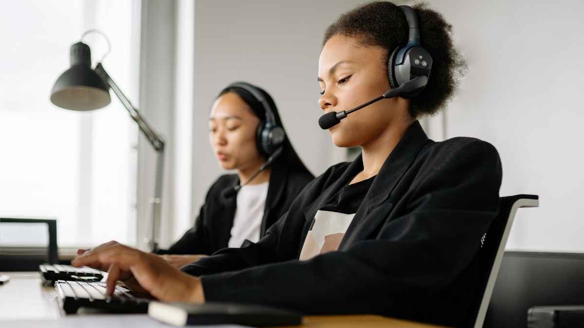 Operadoras de atención telefónica trabajando con auriculares en una oficina para ilustrar las llamadas comerciales y el spam telefónico