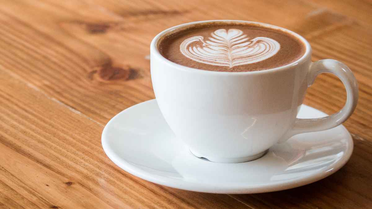 Taza de café sobre una mesa de madera relacionada con sus efectos en los riñones