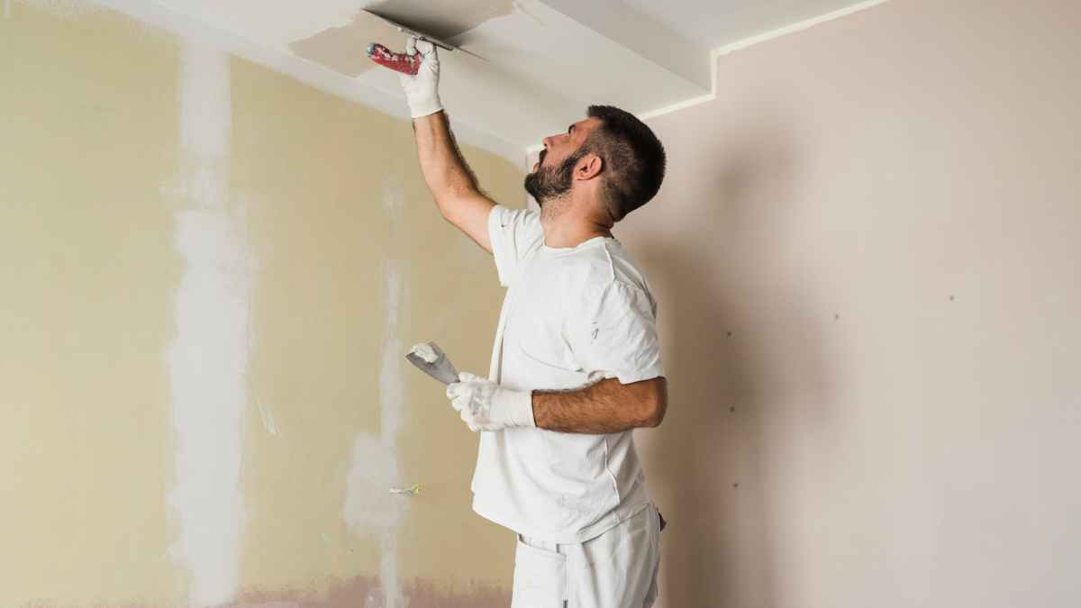 Pintor profesional trabajando en el techo de una vivienda durante una reforma en España en 2026