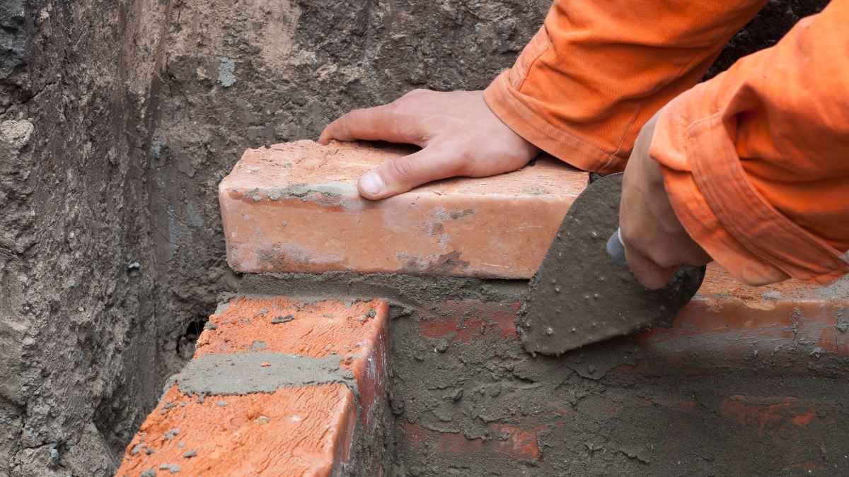 Albañil colocando ladrillos en una obra de construcción