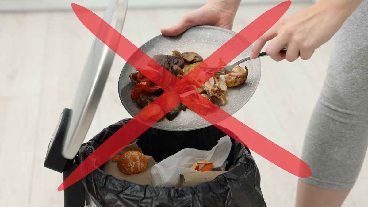 Persona a punto de tirar restos de comida a la basura con una X roja que simboliza “no desperdiciar alimentos”