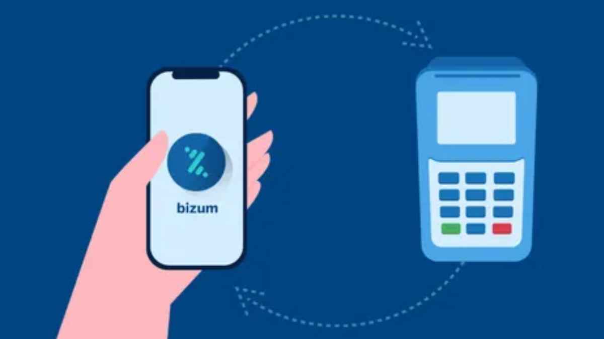 Móvil con Bizum junto a un datáfono para pagar en comercios físicos sin tarjeta