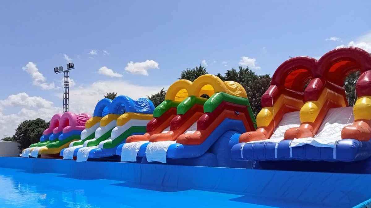 Parque acuático hinchable con grandes toboganes de colores y piscina en Agua Park Toledo
