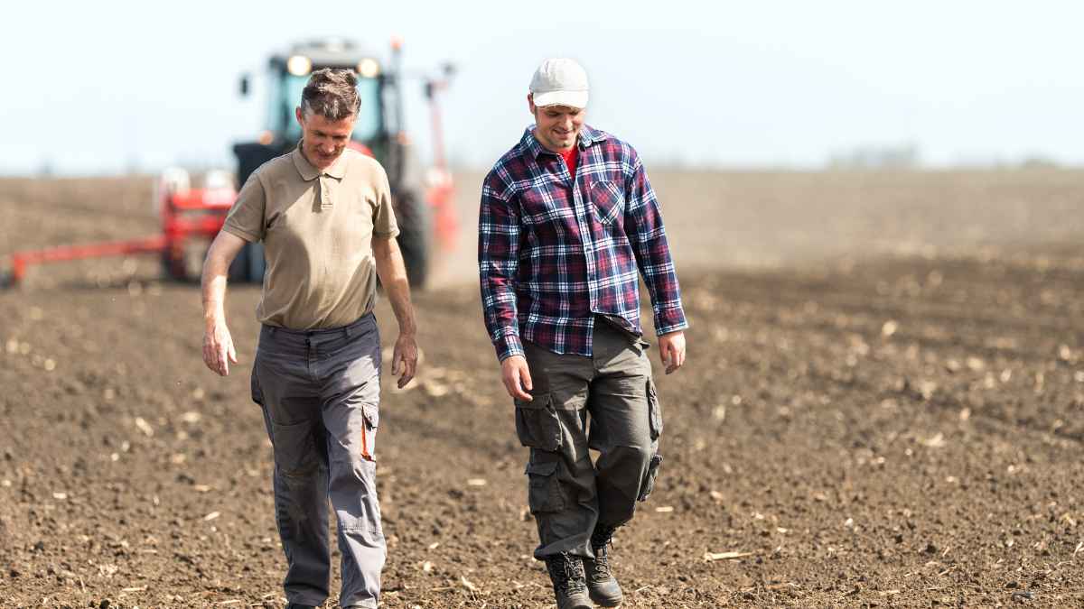 Dos trabajadores caminan por un campo durante una jornada laboral