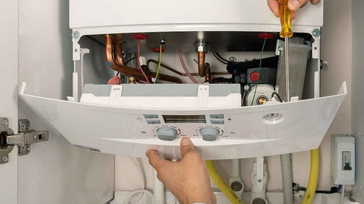Técnico revisando una caldera de gas doméstica para mejorar el consumo y reducir la factura del hogar