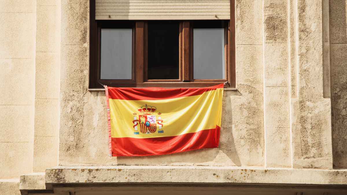 Bandera de España colgada en un balcón de una vivienda.