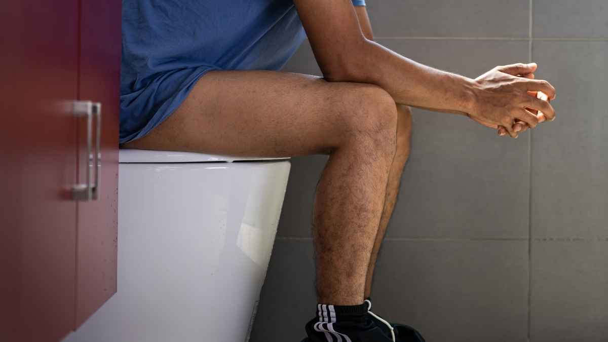Hombre sentado en un baño durante una pausa laboral prolongada de hasta 48 minutos