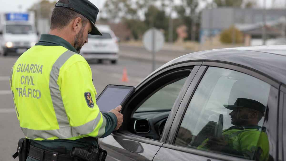 Agente de la Guardia Civil de Tráfico comprobando los datos de un vehículo durante un control de carretera mediante una tablet