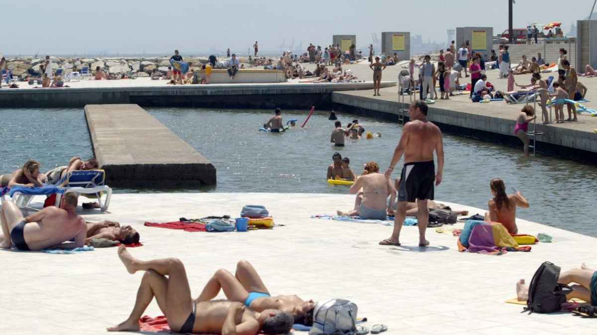 Bañistas tomando el sol y nadando en la Zona de Baños del Fòrum de Barcelona