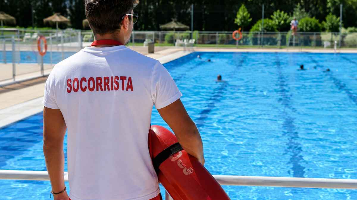Socorrista vigilando una piscina durante una jornada de verano