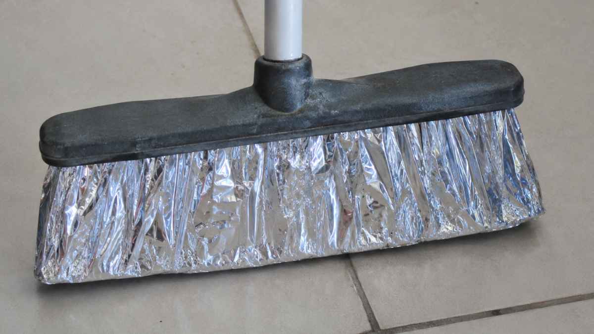 Escoba con papel aluminio en las cerdas para limpiar mejor el suelo