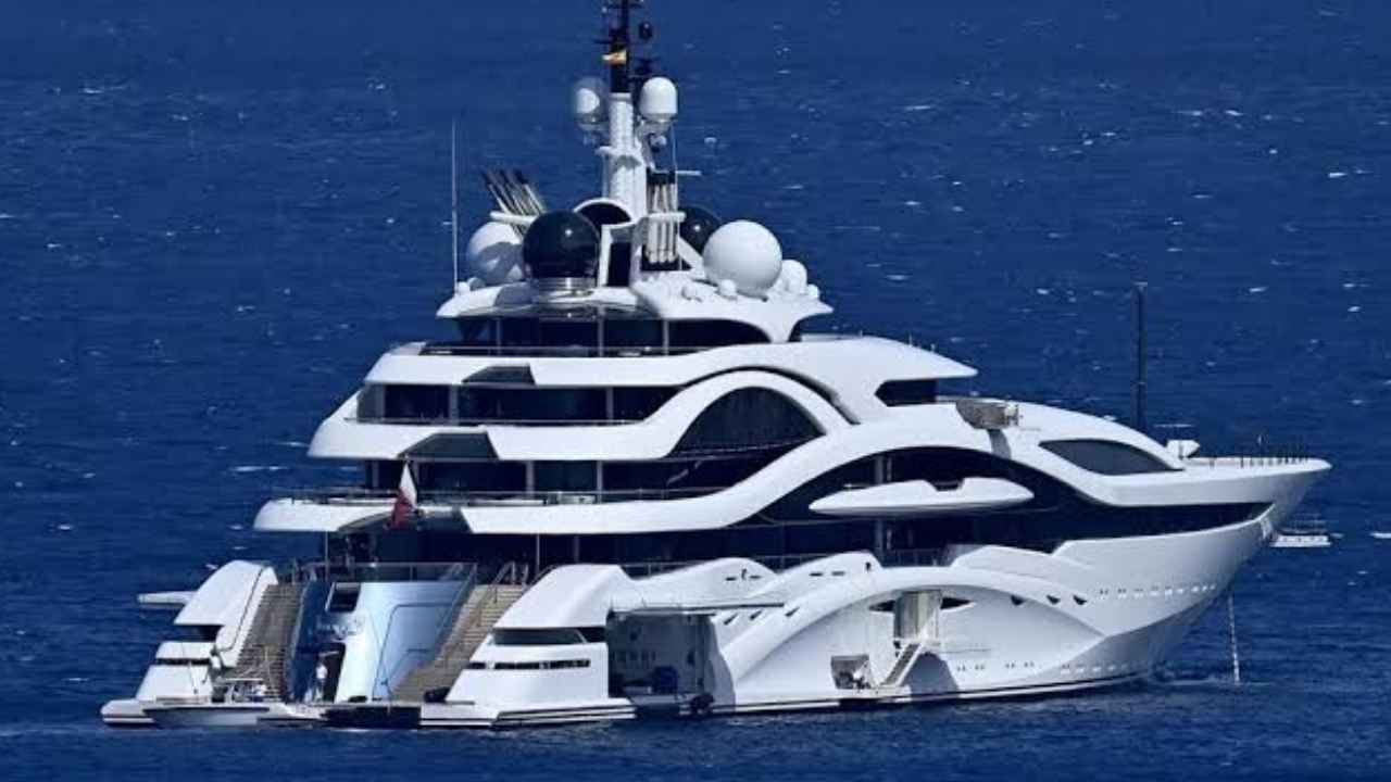 Megayate Al Lusail fondeado frente a una costa rocosa.