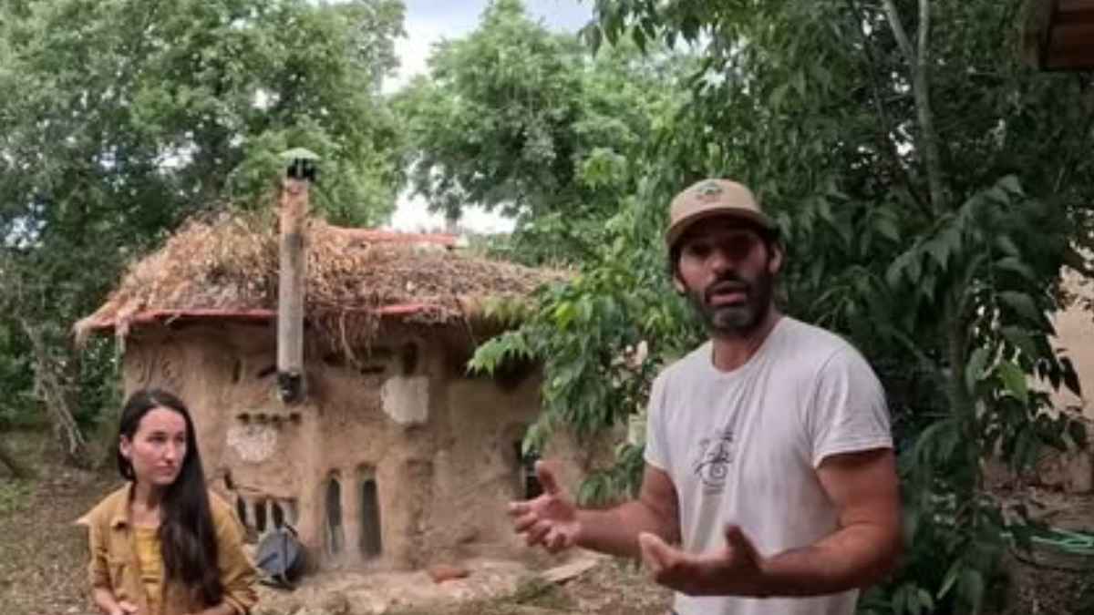 Boris y Rosa junto a su casa sostenible construida con tierra, paja y materiales reciclados