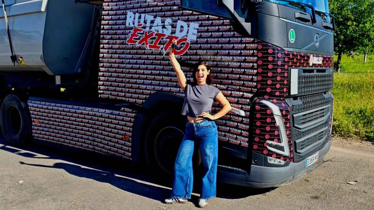 Ainoa Blasco, camionera de 30 años, posa junto a un camión de Rutas de Éxito en un área de descanso.