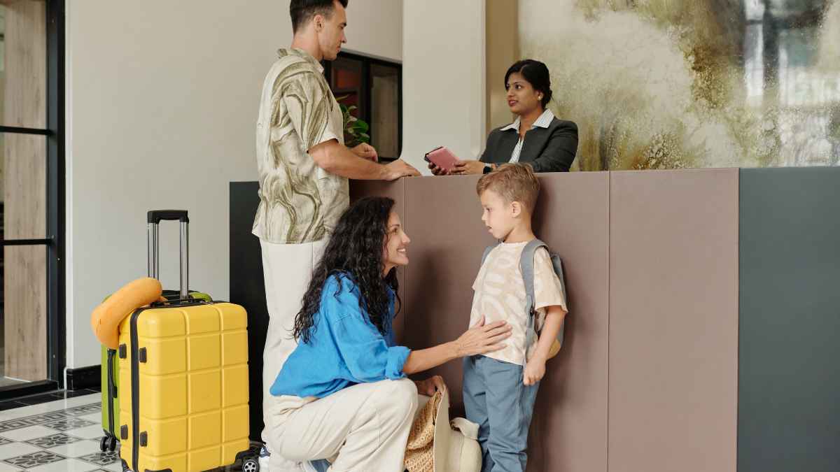 Una familia realiza el check-in en la recepción de un hotel antes de acceder a su habitación.