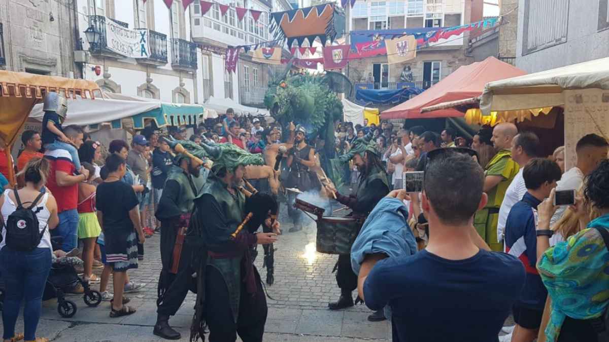 Espectáculo de animación durante la Feria Medieval de Corcubión con visitantes recorriendo los puestos del mercado en la Costa da Morte.
