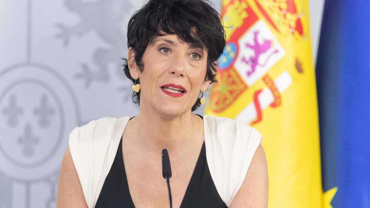 Ministra portavoz durante una comparecencia del Gobierno junto a las banderas de España y la Unión Europea.