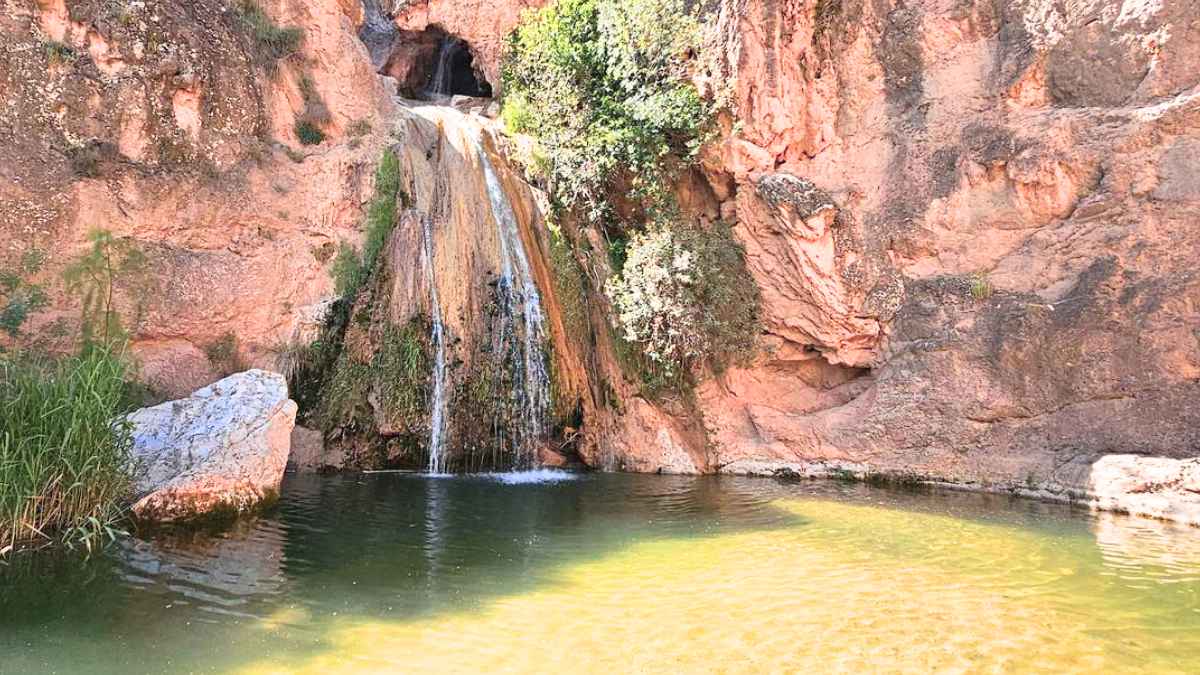 Piscina natural de Las Chorreras en Loja, Granada, con una cascada que desemboca en una poza de aguas cristalinas