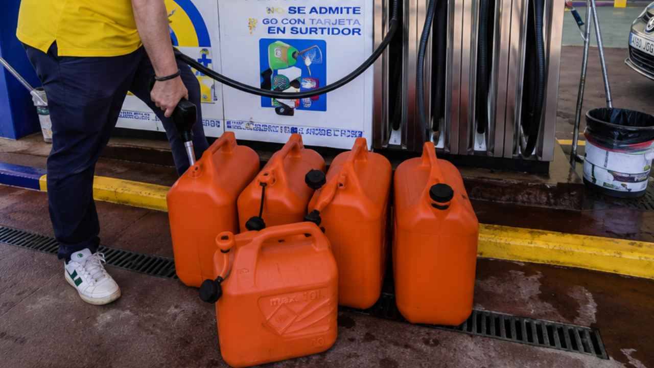 Empleado de una gasolinera repostando combustible en garrafas