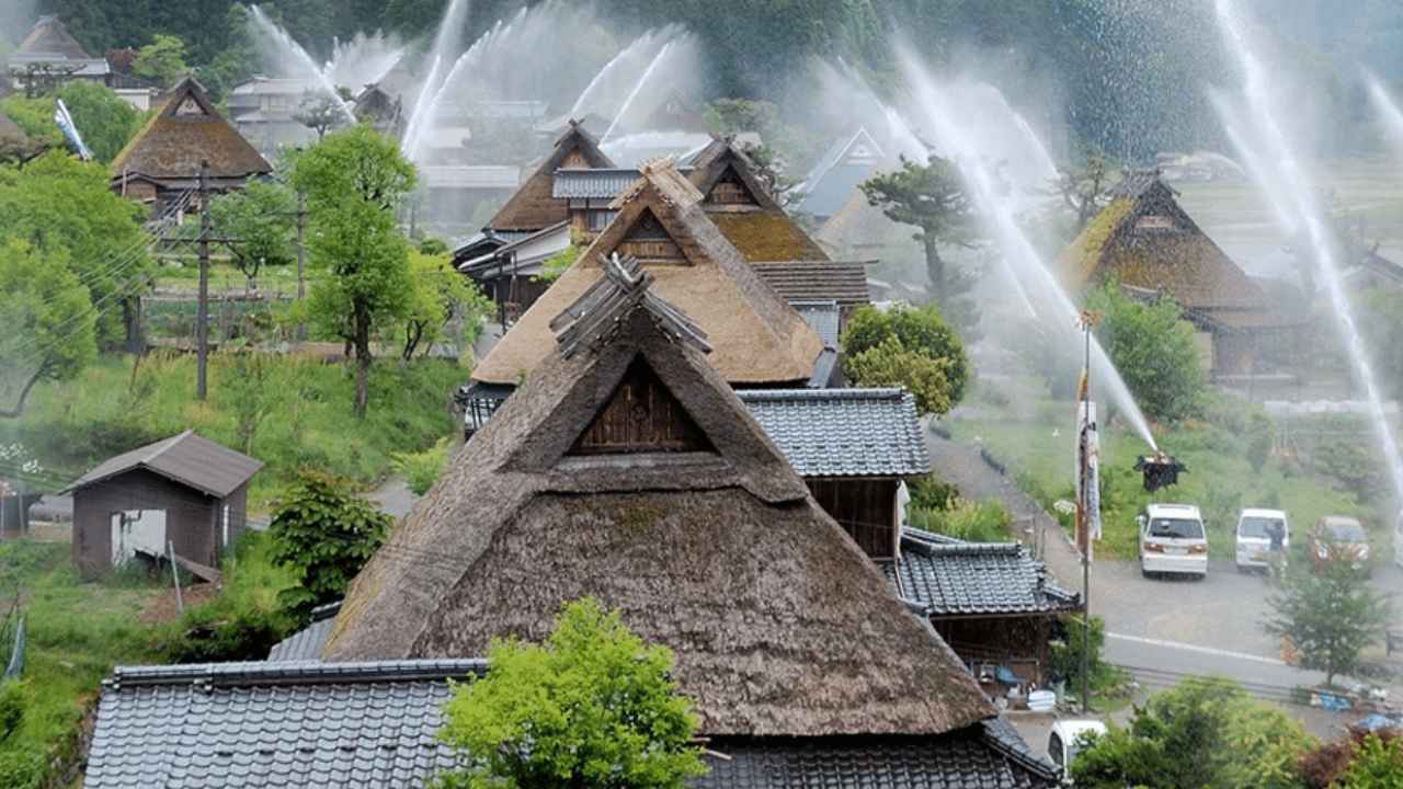 Cañones de agua activados sobre los tejados de paja de Kayabuki no Sato, en Japón