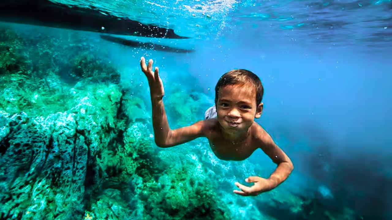 Niño moken buceando con los ojos abiertos bajo el agua