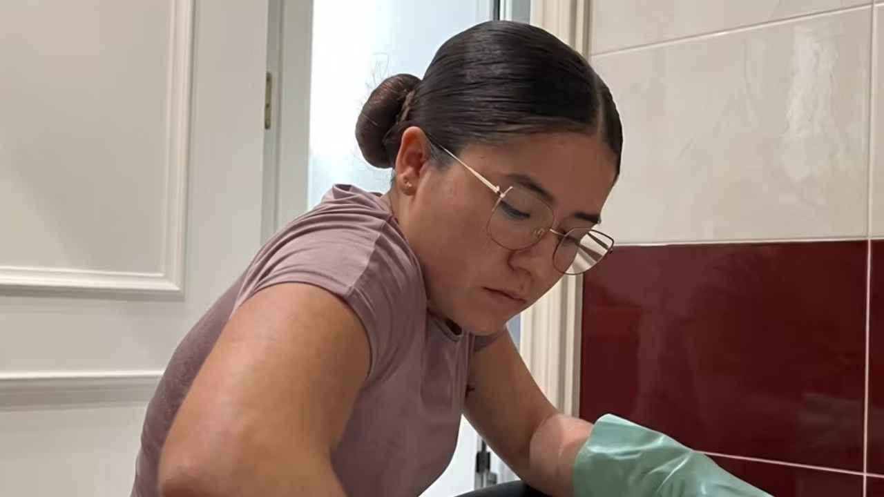 Paulina, limpiadora colombiana en España, realizando tareas de limpieza en una vivienda