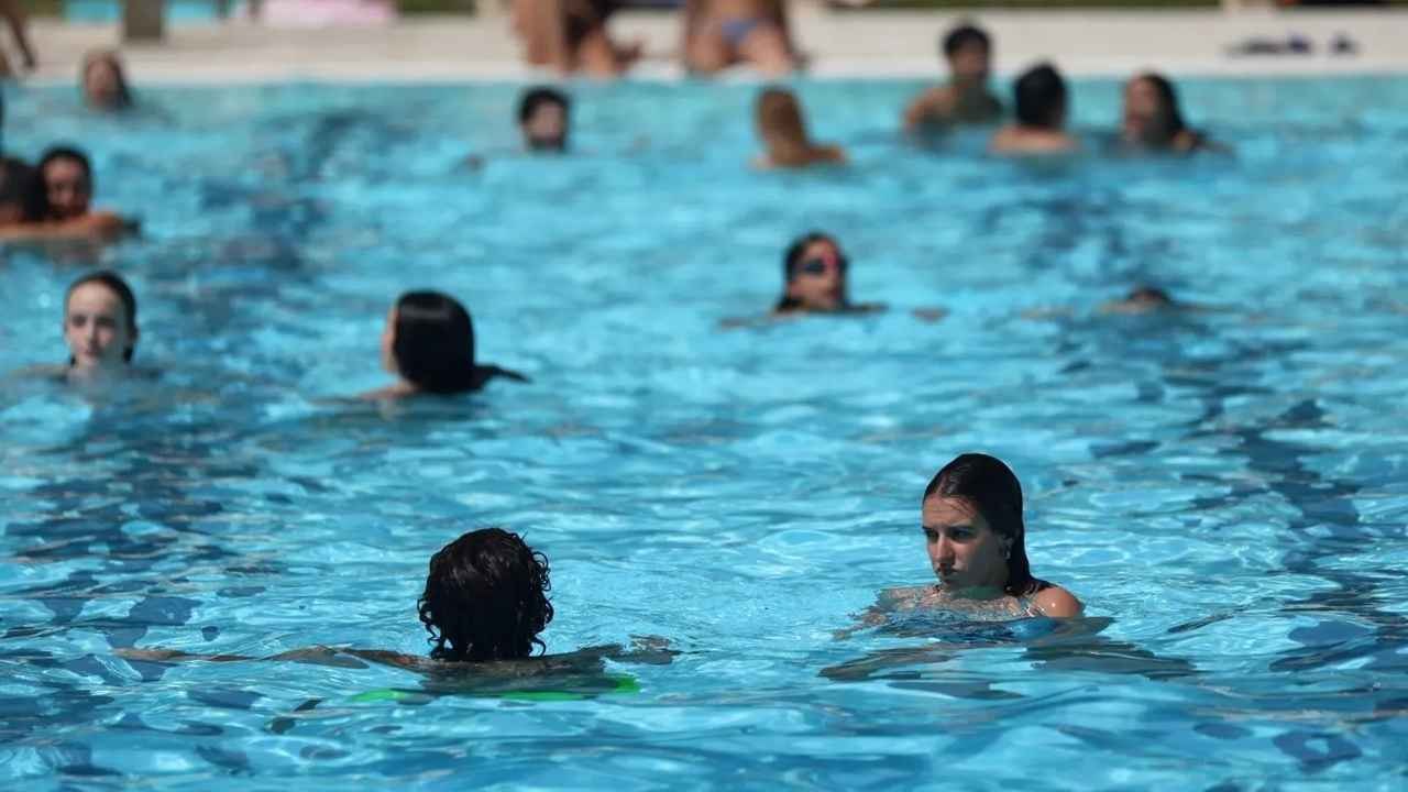Bañistas en una piscina pública exterior durante una jornada de verano