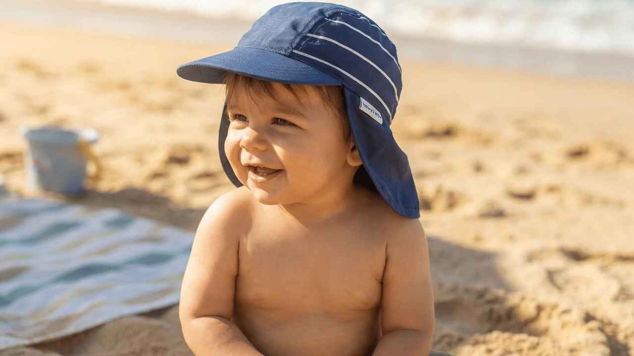 Persona protegida del sol con sombrero y ropa ligera mientras permanece a la sombra