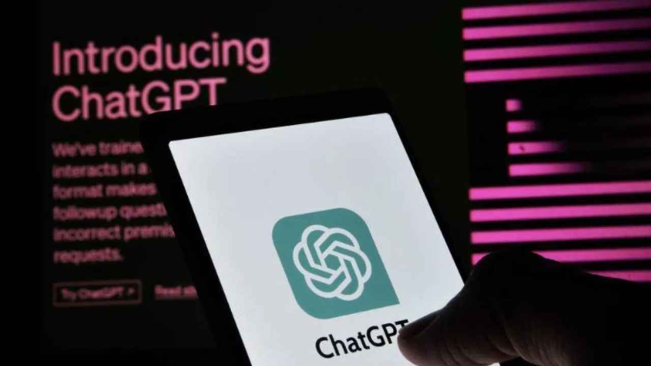 ChatGPT en un teléfono móvil junto a una pantalla con información sobre la herramienta