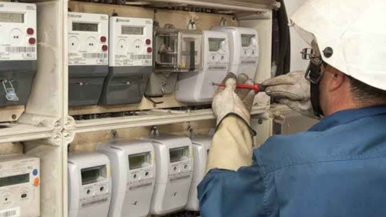 Técnico revisando varios contadores eléctricos en un cuadro de suministro