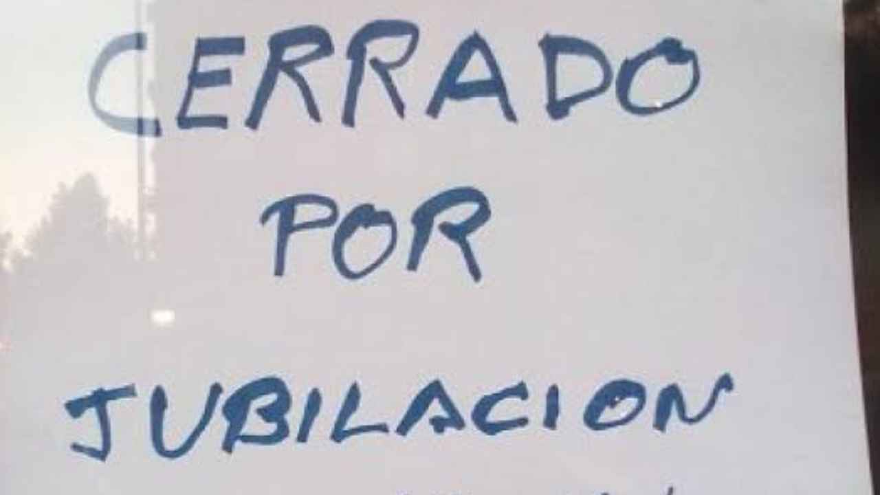 Cartel de cerrado por jubilación colocado en el escaparate de un negocio