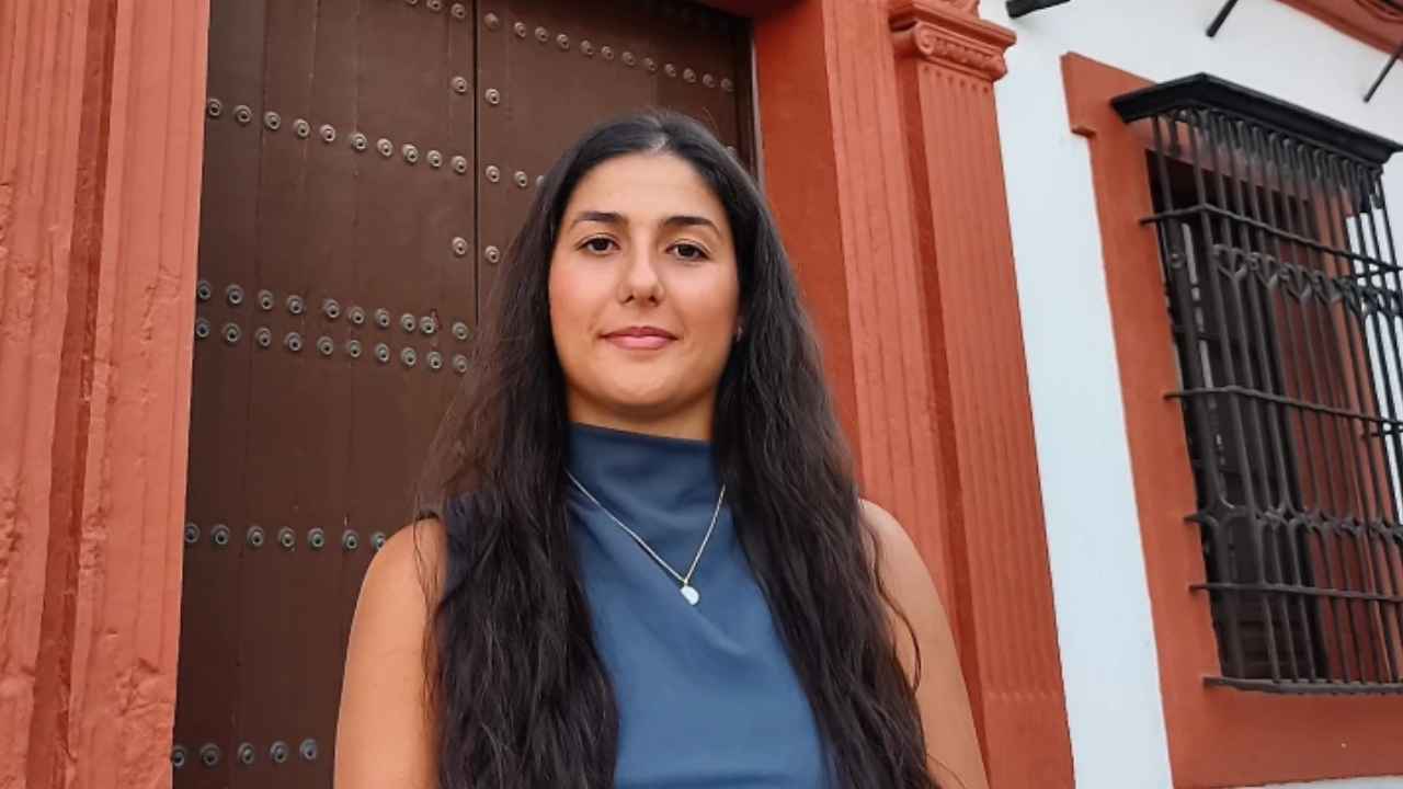 Julia Cejudo, notaria de 23 años, posa ante un edificio de Carmona