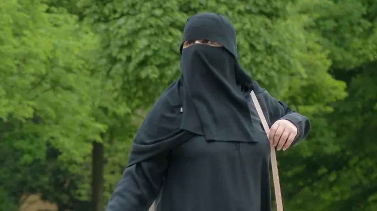 Mujer con nicab negro y el rostro cubierto en un parque