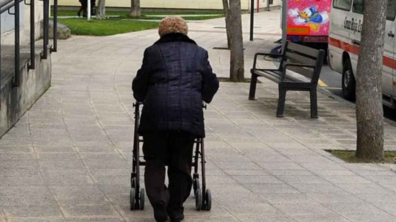 Persona mayor caminando con un andador por la calle