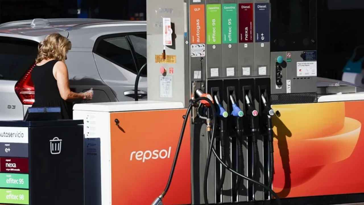 Mujer repostando un coche en una gasolinera Repsol.