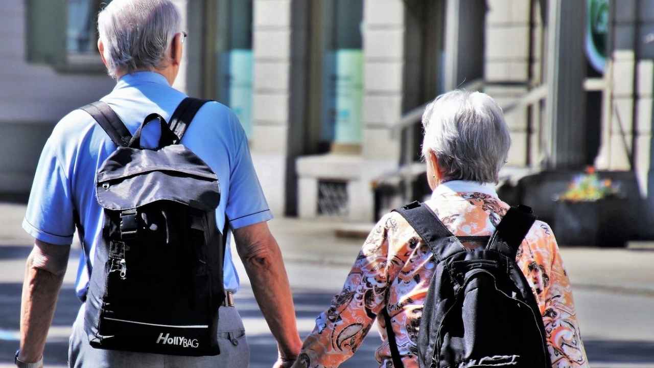 Pareja de pensionistas viajando con mochilas durante un viaje del Imserso
