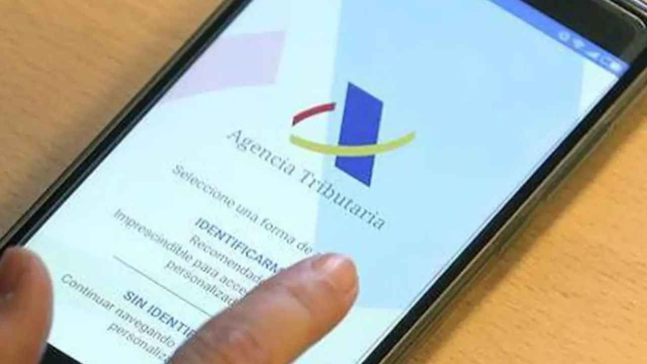 Una persona accede desde su teléfono móvil a la Agencia Tributaria para realizar trámites relacionados con la declaración de la Renta.