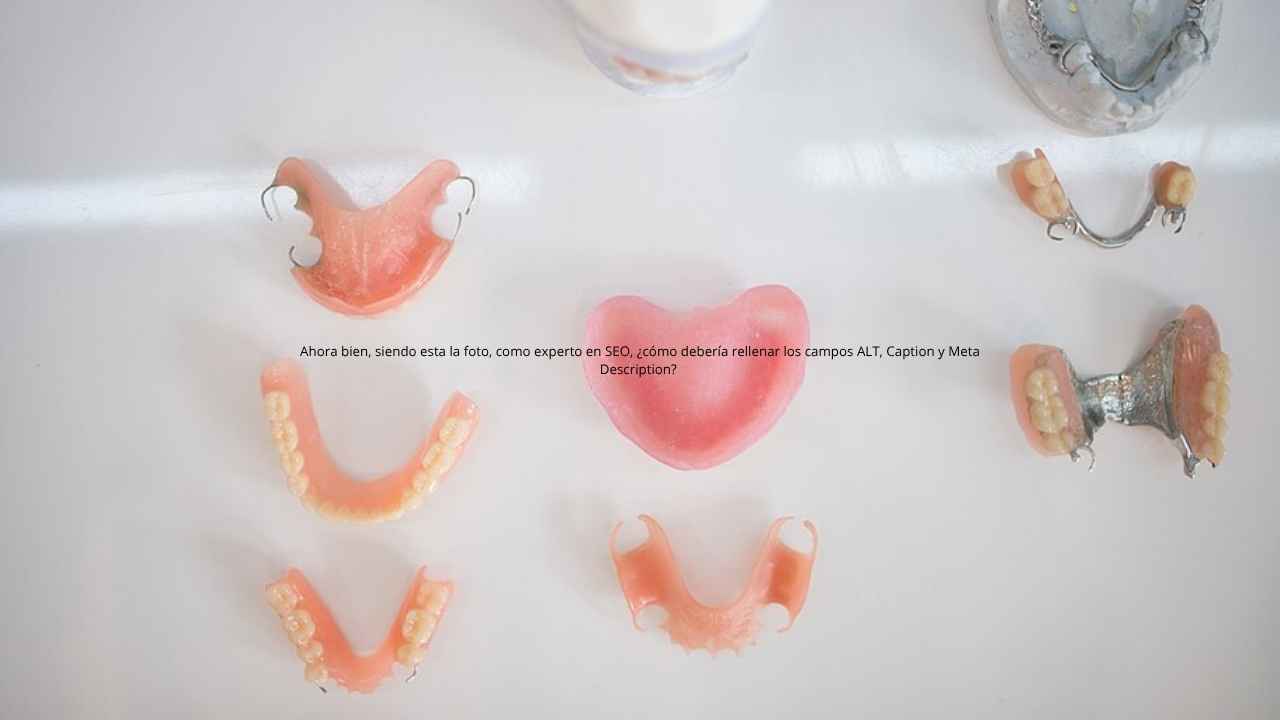 Prótesis dentales removibles y modelos de dentadura colocados sobre una superficie blanca.